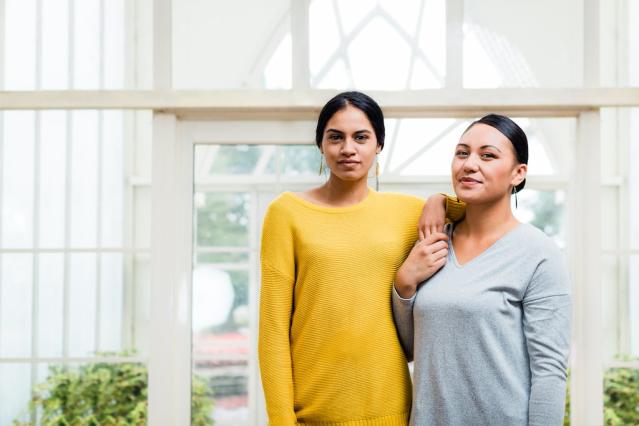 Two women standing next to each other in a supportive pose